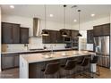 Modern kitchen with a large center island, stainless steel appliances, and dark wood cabinets at 22842 E Via Las Brisas --, Queen Creek, AZ 85142