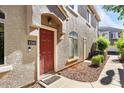 Charming home exterior showcasing a red front door with decorative stone facade and manicured landscaping at 2402 E 5Th St # 1741, Tempe, AZ 85288