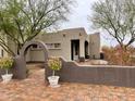 Arched brick walkway leading to the front door, embraced by lovely desert plants at 2427 W Desert Hills Estate Dr, Phoenix, AZ 85086