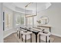Bright dining room featuring a modern chandelier, shuttered windows, and stylish decor at 2662 N Chestnut Cir, Mesa, AZ 85213