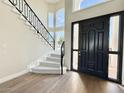 Elegant foyer with a grand staircase, hardwood floors, and a black front door with side lights at 2662 N Chestnut Cir, Mesa, AZ 85213
