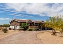 Well-maintained single-story home with a charming front porch and low-maintenance landscaping at 30517 W Lynwood St, Buckeye, AZ 85396