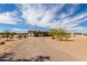 Spacious single-story home with desert landscaping and a long, winding driveway under a cloudy sky at 30517 W Lynwood St, Buckeye, AZ 85396