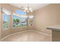 Bright dining area featuring tile floors, a modern chandelier, and large window at 3239 S Tatum Ln, Gilbert, AZ 85297