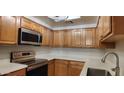 Updated kitchen features stainless steel appliances, modern lighting and wooden cabinets at 3434 E Baseline Rd # 168, Phoenix, AZ 85042