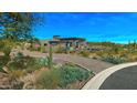 Desert landscaping complements the brick driveway leading to the modern home at 41639 N 113Th Pl, Scottsdale, AZ 85262