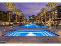 Inviting pool area lined with palm trees and lounge chairs at dusk at 5250 E Deer Valley Dr # 440, Phoenix, AZ 85054