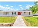 Charming single-story home with a vibrant red front door, manicured lawn, and inviting walkway at 737 E 7Th Pl, Mesa, AZ 85203