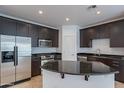 This kitchen features stainless steel appliances, dark cabinets, tile floors, and an island at 945 E Playa Del Norte Dr # 3002, Tempe, AZ 85288