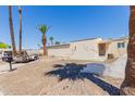 Charming single-story home featuring desert landscaping and mature palm trees for a tranquil outdoor setting at 10472 W Devonshire Ave, Phoenix, AZ 85037