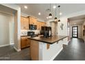 Modern kitchen featuring an island, wooden cabinets, and pendant lighting at 11623 W Marguerite Ave, Avondale, AZ 85323