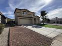 View of a two-story home highlighting the driveway and front exterior at 13171 W Redfield Rd, Surprise, AZ 85379