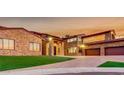 Beautiful stone home with lush lawn and a driveway leading to a three car garage at 15217 N 15Th Dr, Phoenix, AZ 85023