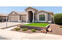 Charming single-story home featuring a well-manicured front yard, tile roof, and a three-car garage at 1932 S Arroyo Ln, Gilbert, AZ 85295