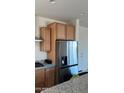 Modern kitchen featuring stainless steel refrigerator and light wood cabinets at 19889 W Annika Dr, Litchfield Park, AZ 85340