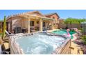 Inviting backyard with hot tub, covered patio, and outdoor bar, perfect for relaxation and entertaining at 22783 W Cantilever St, Buckeye, AZ 85326