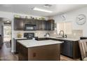 Stylish kitchen with dark cabinets, marble countertops, and a functional center island at 22783 W Cantilever St, Buckeye, AZ 85326
