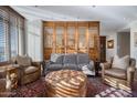 Comfortable living room with hardwood floors, wooden screen accent wall, and large windows at 2402 E Esplanade Ln # 1101, Phoenix, AZ 85016