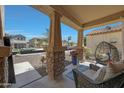 Inviting front porch with decorative columns, chairs, and a view of the neighborhood at 30185 W Flower St, Buckeye, AZ 85396