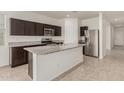 A kitchen featuring granite countertops, stainless steel appliances, and dark wood cabinets at 3480 N 307Th Dr, Buckeye, AZ 85396