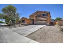 Charming two-story home with a large driveway, two-car garage, and low-maintenance desert landscaping at 40437 W Robbins Dr, Maricopa, AZ 85138