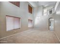 Bright living room featuring high ceilings, neutral carpet, lots of natural light and an open floor plan at 40437 W Robbins Dr, Maricopa, AZ 85138