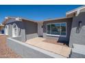 Close up of a home's entrance showing gray stucco, a white front door, and desert landscaping at 4506 W Golden Ln, Glendale, AZ 85302