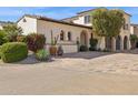 Beautiful exterior of the home with arched entryway, mature landscaping, and a brick driveway at 4949 E Lincoln Dr # 11, Paradise Valley, AZ 85253