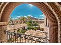 A scenic view of the property's tile roofs and desert landscaping framed by a decorative archway at 4949 E Lincoln Dr # 11, Paradise Valley, AZ 85253