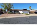Attractive single-story home with desert landscaping, mature trees, and a two-car garage at 5002 W Christy Dr, Glendale, AZ 85304
