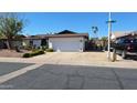 Inviting single-story home with a spacious driveway and well-maintained landscaping at 5002 W Christy Dr, Glendale, AZ 85304