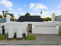 Well-maintained one-story home with white exterior, dark roof, complemented by green lawn and stylish modern black-accented door at 5318 N 24Th Pl, Phoenix, AZ 85016