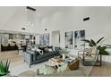 Bright, open-concept living room with modern furnishings, high ceilings, and an adjacent kitchen and dining area at 5318 N 24Th Pl, Phoenix, AZ 85016