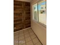 Bright room with tile floors and wood accent wall with a view of the exterior at 5929 N 48Th Ave, Glendale, AZ 85301