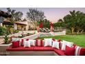 Lush backyard features a cozy outdoor seating area with red cushions and a well-maintained lawn at 6019 N 62Nd Pl, Paradise Valley, AZ 85253
