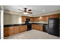 Well-lit kitchen features warm wood cabinetry and black appliances at 6448 E Paso Nuevo Dr # 101, Cave Creek, AZ 85331