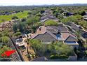 Aerial view of the desert home and golf course community, featuring a pool, patio, and desert landscaping at 6591 E Amber Sun Dr, Scottsdale, AZ 85266