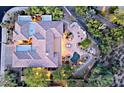 An aerial view of desert home's outdoor living space, featuring a pool, patio, and desert landscaping at 6591 E Amber Sun Dr, Scottsdale, AZ 85266
