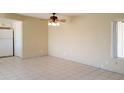 Living room featuring neutral walls and tile flooring, with ceiling fan and window at 7506 W Devonshire Ave, Phoenix, AZ 85033