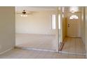 Bright living room with tile flooring, ceiling fan, and front entry door at 7506 W Devonshire Ave, Phoenix, AZ 85033