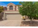 Two-story home with a beige stucco exterior, red tile roof, and a large two-car garage offering classic architectural style at 826 W Devon Dr, Gilbert, AZ 85233