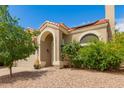 Beige stucco home with a red tile roof, arched entryway, and desert landscaping for a charming curb appeal at 826 W Devon Dr, Gilbert, AZ 85233