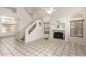 Bright living room with soaring ceilings, a cozy fireplace, and staircase, with large tile floors for a modern look at 826 W Devon Dr, Gilbert, AZ 85233