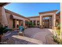 A beautiful courtyard with desert landscaping and a fireplace at 8392 E Eagle Feather Rd, Scottsdale, AZ 85266