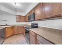 A bright kitchen features tile flooring, stainless steel appliances, plenty of cabinets, and stone countertops at 8787 E Mountain View Rd # 1087, Scottsdale, AZ 85258