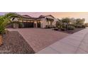Paver driveway leading to a home with a three-car garage and well-manicured landscaping at 9369 W Via Montoya Dr, Peoria, AZ 85383