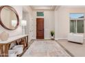 Inviting foyer with a round mirror, wood accents, and neutral decor at 9369 W Via Montoya Dr, Peoria, AZ 85383