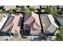 An aerial view of closely spaced homes with tile roofs, showcasing the residential neighborhood, manicured landscaping, and driveways at 10031 W Hess St, Tolleson, AZ 85353