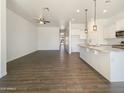 Spacious living area flows into a bright kitchen with a large island and modern pendant lighting at 10531 E Nopal Ave, Mesa, AZ 85209