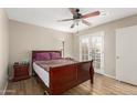 Bedroom with wood-look flooring, ceiling fan, and access to the outdoor patio at 1217 N Miller Rd # 32, Scottsdale, AZ 85257